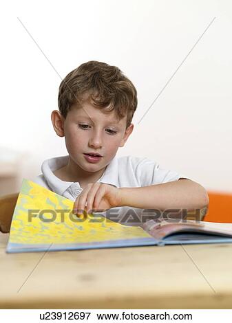 Stock Photo - Learning to read. 6 year old boy learning to read.. Fotosearch