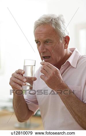 Stock Photo - Man taking a pill.. Fotosearch