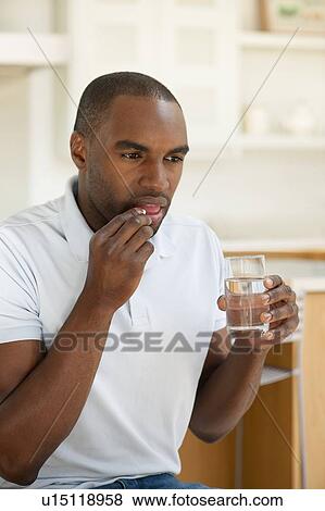 Man taking a pill. View Large Photo Image Stock Photo - Man taking a pill.. Fotosearch