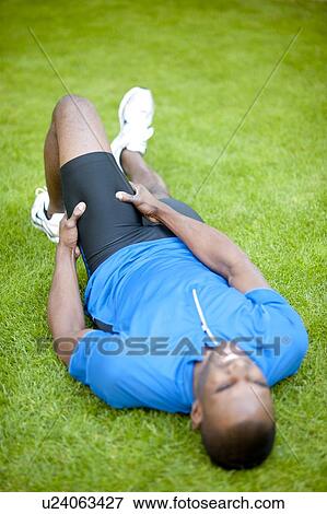 Stock Photo - Man with cramp in his thigh.. Fotosearch