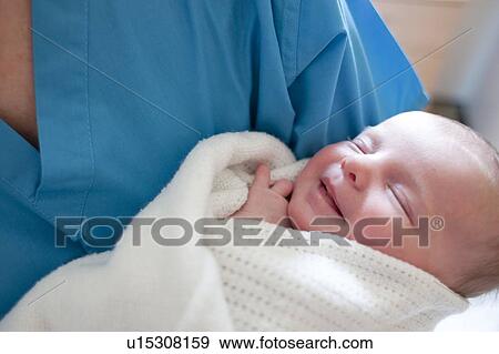 Newborn baby held by a nurse. View Large Photo Image Stock Photo - Newborn baby held by a nurse.. Fotosearch