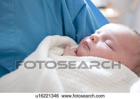 Newborn baby held by a nurse. View Large Photo Image Stock Photograph - Newborn baby held by a nurse.. Fotosearch
