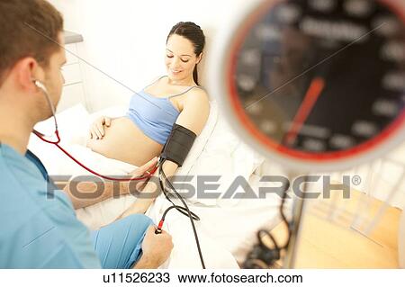Obstetric examination. Midwife measuring a pregnant woman's blood pressure at a birthing centre. View Large Photo Image Stock Image - Obstetric examination. Midwife measuring a pregnant woman's blood pressure at a birthing centre.. Fotosearch