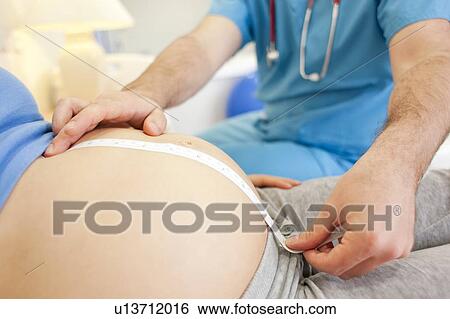 Obstetric examination. Midwife measuring a pregnant woman's abdomen at a birthing centre. View Large Photo Image Stock Photograph - Obstetric examination. Midwife measuring a pregnant woman's abdomen at a birthing centre.. Fotosearch