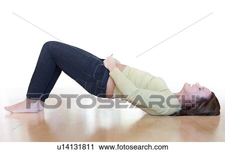 Stock Image - Overweight woman struggling to do her jeans up.. Fotosearch