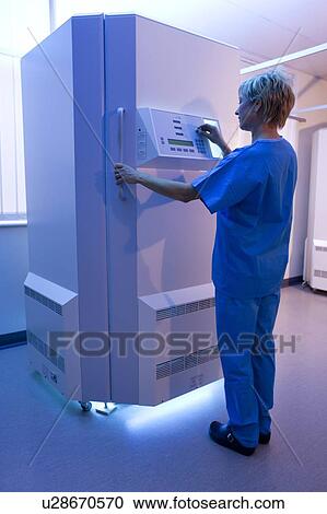 Stock Image - Phototherapy booth. Dermatologist setting up an ultraviolet B phototherapy booth.. Fotosearch