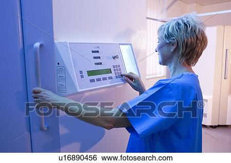 Stock Photograph - Phototherapy booth. Dermatologist setting up an ultraviolet B phototherapy booth.. Fotosearch