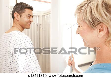 Stock Photo - Phototherapy. Dermatologist helping a patient into a phototherapy booth.. Fotosearch