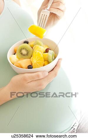 Pregnant woman eating a fruit salad. View Large Photo Image Picture - Pregnant woman eating a fruit salad.. Fotosearch