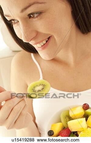 Stock Photo - Pregnant woman eating a fruit salad.. Fotosearch
