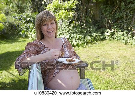 Pregnant woman eating cake in a garden. She is 35 weeks pregnant. View Large Photo Image Stock Image - Pregnant woman eating cake in a garden. She is 35 weeks pregnant.. Fotosearch