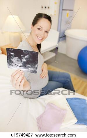 Stock Photo - Pregnant woman with her baby scan in a room at a birthing centre.. Fotosearch