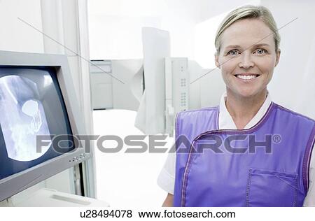 Radiographer next to a screen showing a barium X-ray. View Large Photo Image Stock Photo - Radiographer next to a screen showing a barium X-ray.. Fotosearch