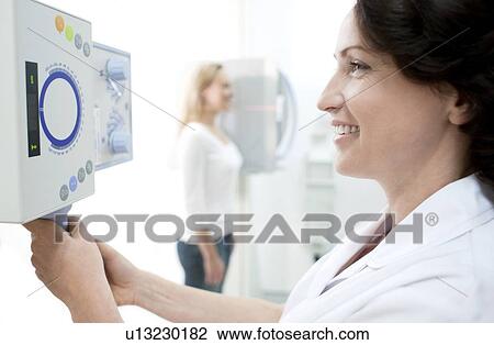 Radiographer taking an X-ray of a woman's neck. View Large Photo Image Stock Image - Radiographer taking an X-ray of a woman's neck.. Fotosearch