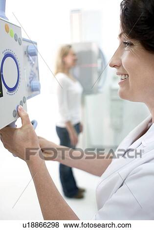 Radiographer taking an X-ray of a woman's neck. View Large Photo Image Stock Photo - Radiographer taking an X-ray of a woman's neck.. Fotosearch