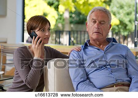 Senior man having a stroke. He is experiencing facial weakness. A woman is phoning for an ambulance. View Large Photo Image Stock Photo - Senior man having a stroke. He is experiencing facial weakness. A woman is phoning for an ambulance.. Fotosearch