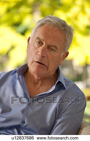 Stock Photograph - Senior man having a stroke. He is experiencing facial weakness.. Fotosearch