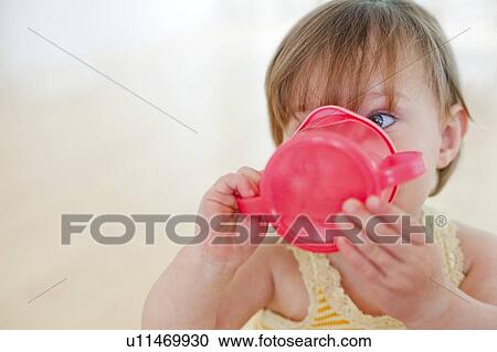 Toddler drinking. 15 month old girl drinking from a training cup. View Large Photo Image Stock Image - Toddler drinking. 15 month old girl drinking from a training cup.. Fotosearch