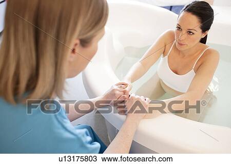 Water birth. Midwife holding the hands of a pregnant woman who is in a birthing pool. View Large Photo Image Stock Image - Water birth. Midwife holding the hands of a pregnant woman who is in a birthing pool.. Fotosearch