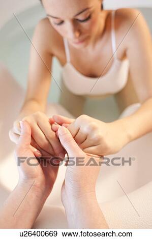 Stock Photo - Water birth. Midwife holding the hands of a pregnant woman who is in a birthing pool.. Fotosearch