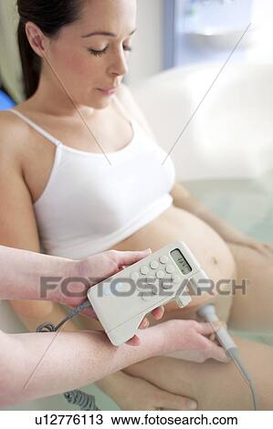 Water birth. Midwife using a doppler monitor to listen to a foetus' heartbeat in a birthing pool. View Large Photo Image Stock Image - Water birth. Midwife using a doppler monitor to listen to a foetus' heartbeat in a birthing pool.. Fotosearch