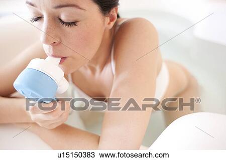 Stock Image - Water birth. Pregnant woman taking gas and air in a birthing pool.. Fotosearch