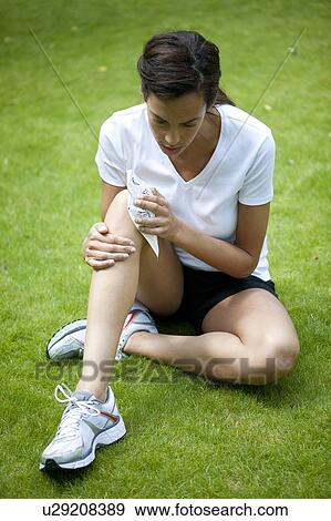 Woman applying an ice pack to her injured knee. View Large Photo Image Stock Photo - Woman applying an ice pack to her injured knee.. Fotosearch