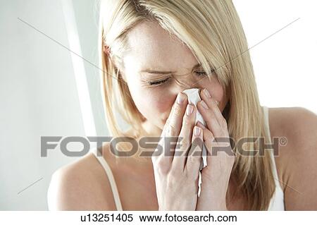 Stock Photography - Woman blowing her nose.. Fotosearch