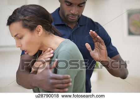 Woman choking. The man is trying to dislodge the foreign object by hitting her between the shoulder blades. View Large Photo Image Stock Photo - Woman choking. The man is trying to dislodge the foreign object by hitting her between the shoulder blades.. Fotosearch
