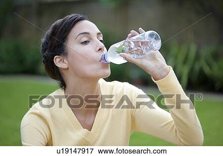 Woman drinking bottled water. View Large Photo Image Stock Photo - Woman drinking bottled water.. Fotosearch