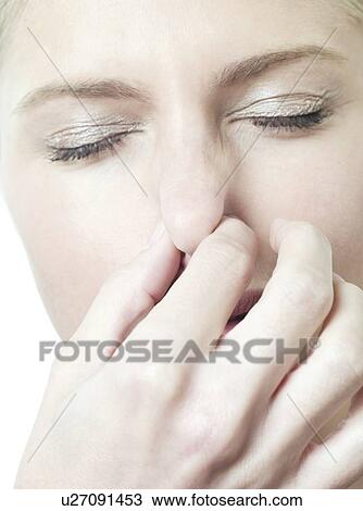 Stock Image - Woman holding her nose.. Fotosearch