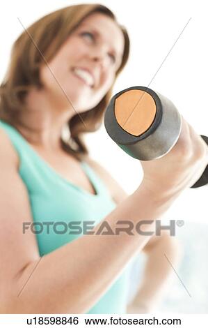 Stock Photograph - Woman lifting weights.. Fotosearch