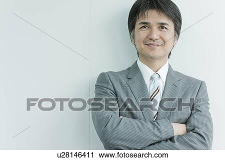 Stock Image - A businessman holding arms. Fotosearch