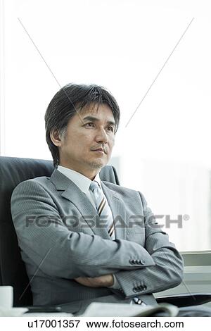 Stock Photo - A businessman holding arms. Fotosearch