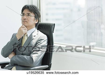 Stock Photography - A businessman holding arms. Fotosearch