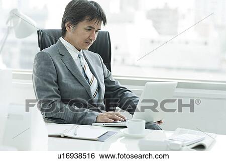 A businessman in the office View Large Photo Image Stock Photograph - A businessman in the office. Fotosearch