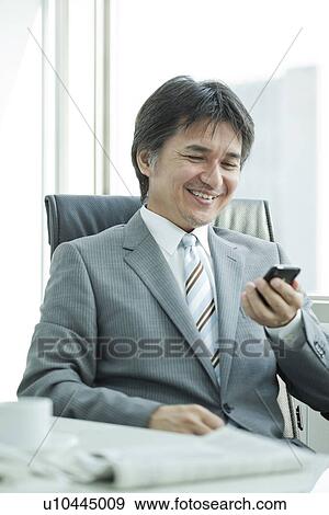 A businessman using a smart phone View Large Photo Image Stock Photo - A businessman using a smart phone. Fotosearch