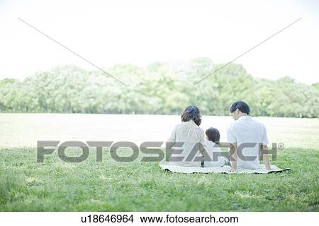 Picture - A family sitting at the park. Fotosearch