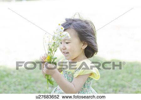 Stock Image - A girl holding flowers. Fotosearch