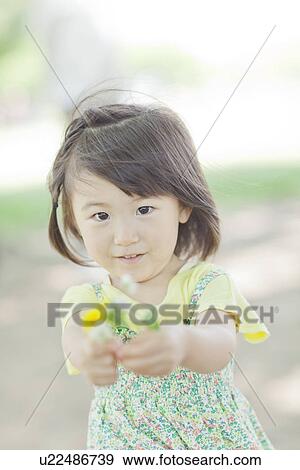 Stock Photo - A girl holding flowers. Fotosearch