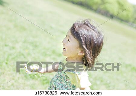 Stock Photograph - A girl holding flowers. Fotosearch