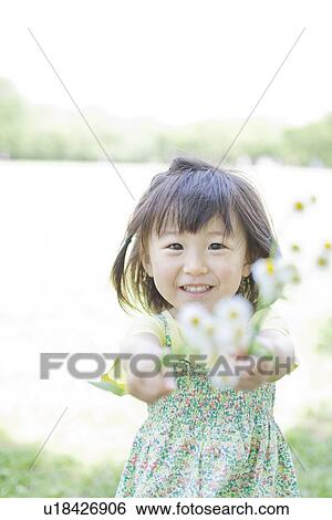 Stock Photograph - A girl holding flowers. Fotosearch