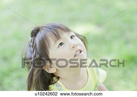 Stock Image - A girl looking up. Fotosearch