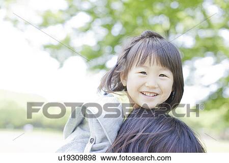 Stock Photo - A girl on mother's back. Fotosearch