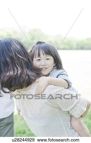 Stock Photo - A girl on mother's back. Fotosearch