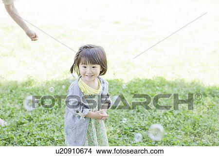 Picture - A girl playing bubbles. Fotosearch