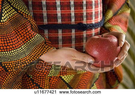Stock Image - A woman holding an apple. Fotosearch