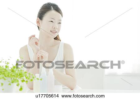 Picture - A young woman taking care of face skin. Fotosearch