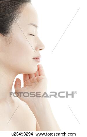Picture - A young woman taking care of face skin. Fotosearch