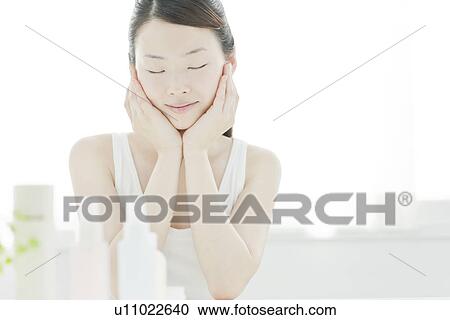 A young woman taking care of face skin View Large Photo Image Stock Image - A young woman taking care of face skin. Fotosearch